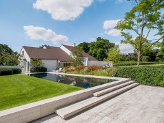 Biopool Bouwkundig overloopzwembad in natuursteen in een landelijke omgeving